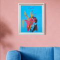 Venado Cyberpunk framed art print by El Zanate on a pink wall above a blue sofa – figure wearing a colorful Guatemalan traditional deer mask on sky-blue background